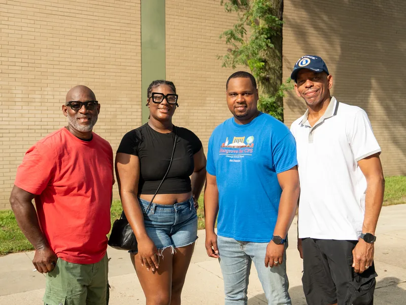 Anthony Hargrove con camisa azul junto a tres adultos al aire libre.