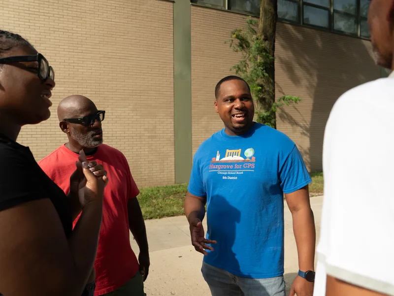 Anthony Hargrove junto a un grupo pequeño durante una conversación al aire libre.