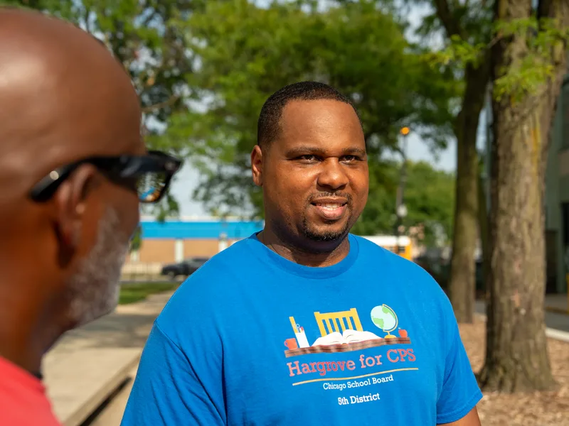 Retrato cercano de Anthony Hargrove con camisa azul durante una reunión al aire libre.