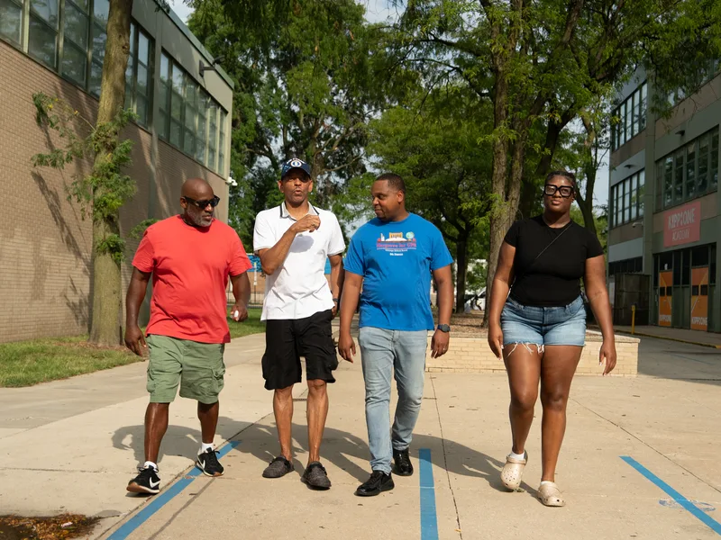 Anthony Hargrove caminando con un grupo pequeño junto a una escuela.