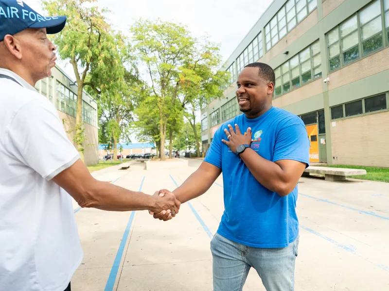 Anthony Hargrove estrechando la mano de un hombre con gorra blanca.