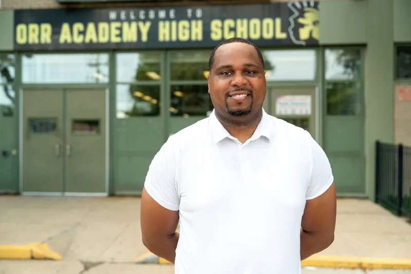 Anthony Hargrove con un polo blanco frente a una escuela.